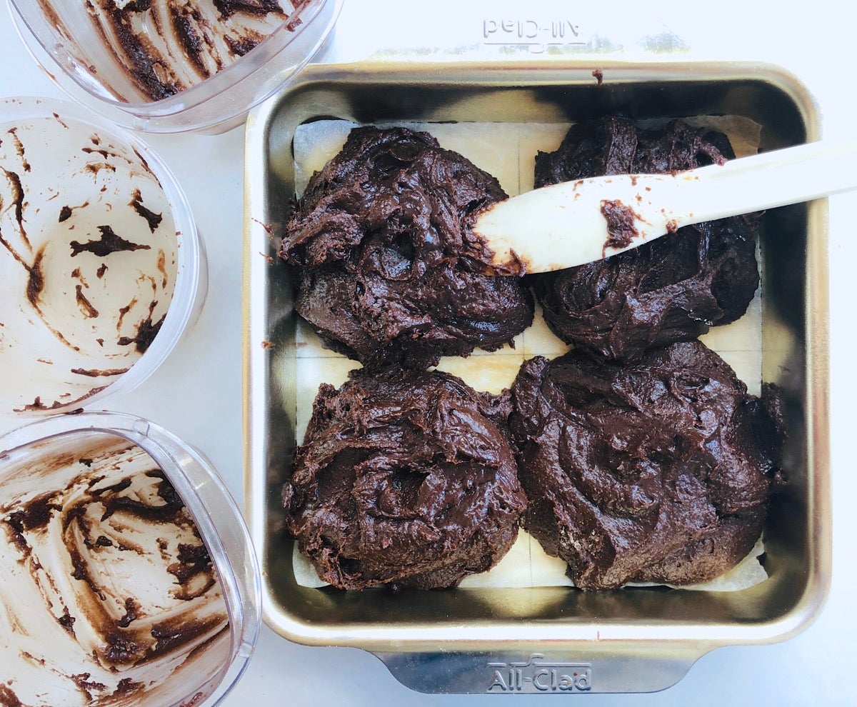 Four types of brownie batter made with different levels of rye flour being spread into a pan prior to baking. 